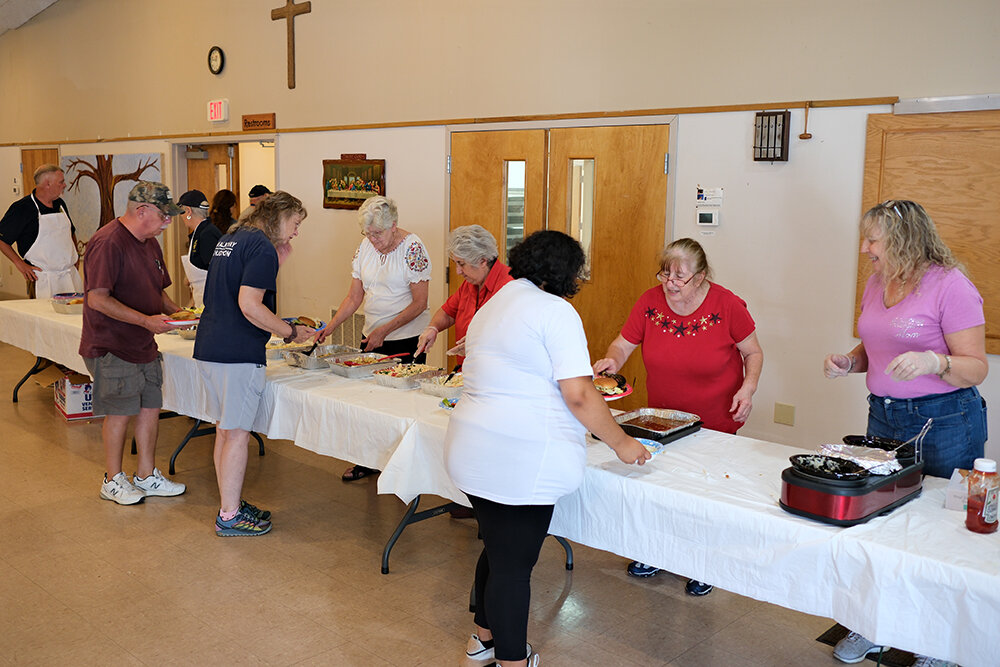 Volunteers served hamburgers, hot dogs, potato salad, cole slaw and drinks.